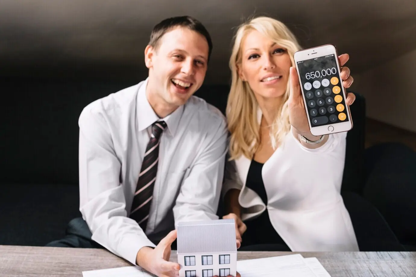 Fröhlicher Immobilienmakler und fröhlicher Kunde, die vom Preis begeistert sind